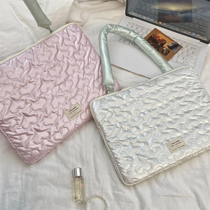 Detailed view of quilted heart pattern laptop sleeves with soft padded handles