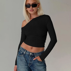 Détail du crop top noir à une épaule et manches longues en tissu texturé avec coupe ajustée