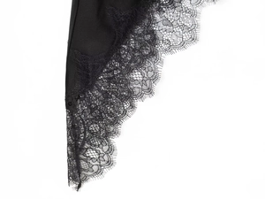 Macro shot of elegant eyelash lace trim on black satin fabric detailing craftsmanship