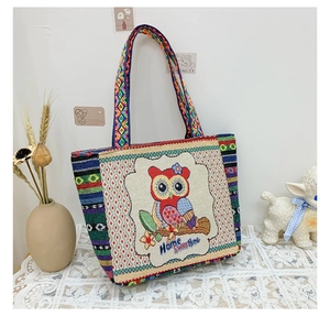 Detail of owl embroidery and woven texture on a bohemian ethnic tote bag