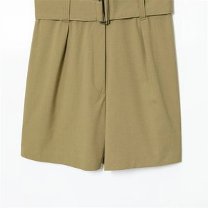 Detail of high-waist olive green romper with matching belt and front pleat accents