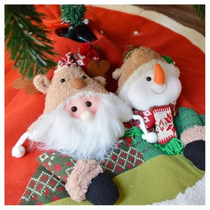 Detailed view of plush Santa and Snowman dolls on a red fabric Christmas tree skirt