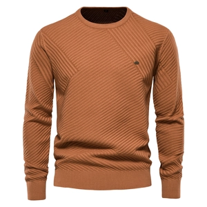 Detailed macro view of caramel knit sweater with twill texture and metal logo