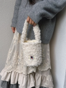 Plush white fleece bucket bag with a cute cartoon cat patch and soft carrying handle