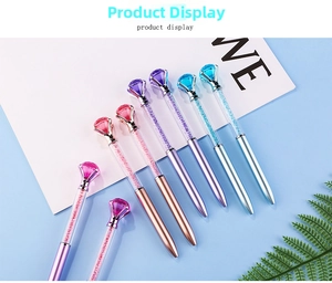 Close-up of colorful crystal ballpoint pens with large diamond top and flowing sand