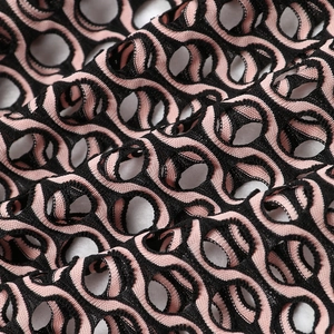 Gros plan sur la dentelle en tricot rose et noir avec des motifs ronds ajourés