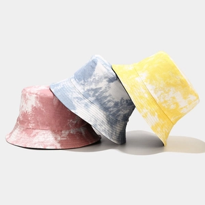 Three tie-dye bucket hats in pink, blue, and yellow showing a stylish reversible street style