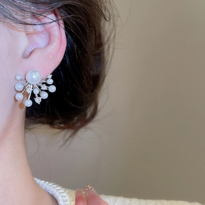 Close-up of model wearing fireworks pearl stud earrings with zircon in silver
