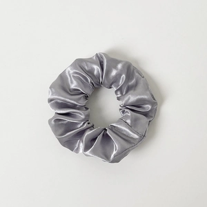 Detailed close-up of silver-grey satin LED scrunchie with soft fabric texture and glowing effect