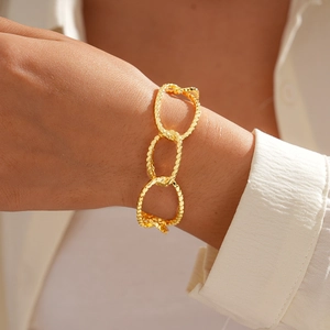 Detail of 18K gold-plated oval chain bracelet with textured finish on female model