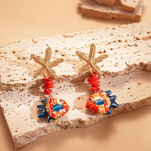 Detail of nautical earrings featuring gold starfish and colorful fish pendants