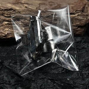 Detail view of silver plated ring with hammered texture on dark wood background