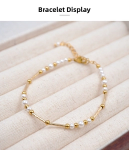 Close-up of gold beaded pearl bracelet with twisted metal tubes and lobster clasp