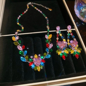 Macro detail of colorful leaf-shaped stones and pink heart gem in a jewelry set