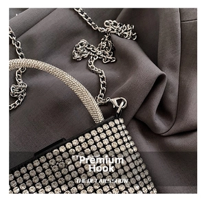 Detailed macro view of silver rhinestones and metal chain hook on evening clutch bag