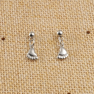 Vue détaillée de clous d'oreilles en acier argenté avec pendentifs pattes mignons