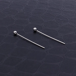Polished silver stainless steel ball head pins for jewelry making on dark textured surface