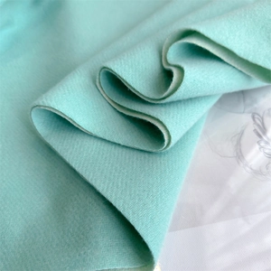 Macro shot of mint green cashmere scarf showing delicate herringbone weave and soft texture