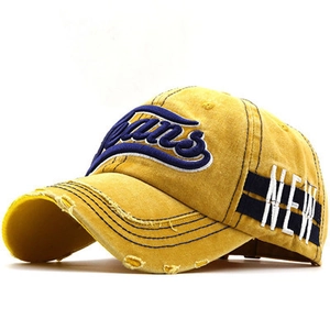 Macro view of 3D Jeans embroidery and distressed details on a yellow denim baseball cap