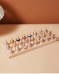 Macro detail of solid wood ring display with multiple conical holders for 24 rings