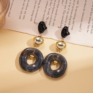 Detail of drop earrings with black resin studs and dark grey marble textured rings