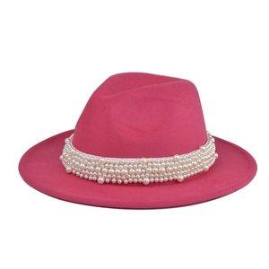 Detalle de sombrero de fieltro de lana rosa con elegante banda decorativa de perlas blancas