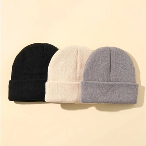 Three minimalist knitted beanies in black, cream, and grey for kids with warm ribbed texture
