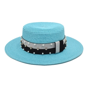 Detail of bright blue straw boater hat with pearl and rhinestone ribbon decoration