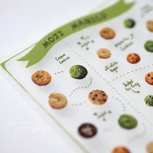 Macro detail of hand-drawn dessert nail stickers with matcha cookies and ribbons