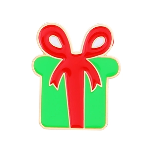Détail d'une épingle émaillée en forme de boîte cadeau verte de Noël avec un nœud rouge