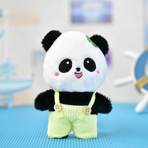 Detailopname van een schattige pluchen panda-sleutelhanger met gele tuinbroek.