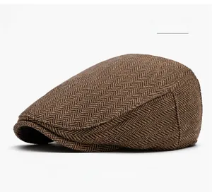 Detail of khaki herringbone tweed newsboy cap showing wool blend fabric texture