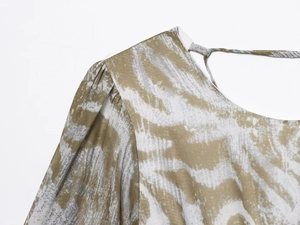 Detalle de hombro fruncido y cuello con lazo en vestido de gasa estampado