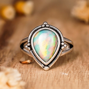Bague vintage argentée en forme de goutte avec opale irisée et bordure perlée ciselée