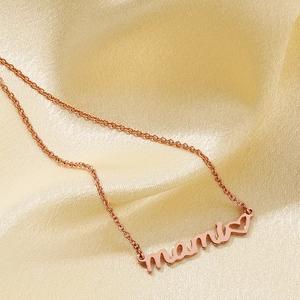 Close-up of rose gold mama necklace with heart pendant on soft gold silk background