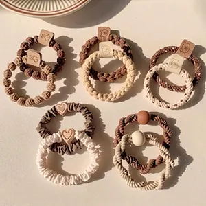 Detail of high ponytail hair tie set with pearl charms and woven fabric texture