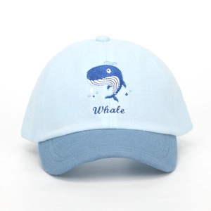 Detail of whale embroidery on a blue two-tone kids baseball cap with soft brim