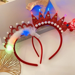 Detail of Christmas headbands with red crown, white feathers and colorful LED lights