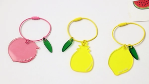 Close-up of peach, pineapple and lemon acrylic charms with colored wire rings