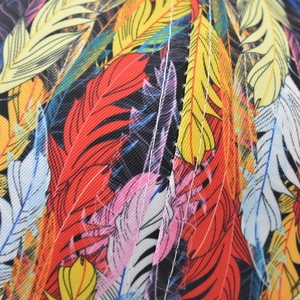 Macro detail of twill fabric showing colorful feather print and white stitching quality