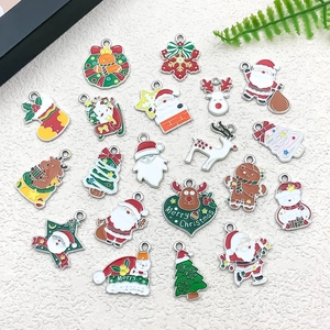 Flat lay of colorful enamel Christmas charms including Santa, reindeer, and snowflakes