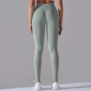 Close-up of light green seamless yoga pants showing V-shaped peach lifting seam detail