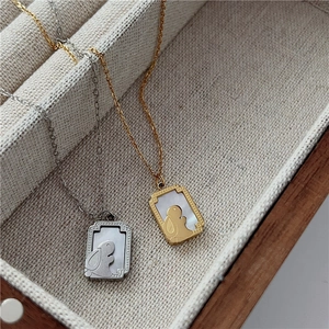 Detail shot of golden and silver rabbit pendants with white mother of pearl inlay