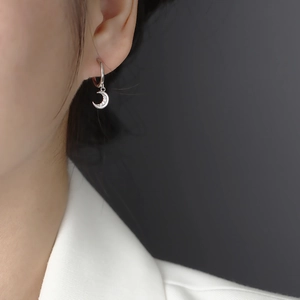 Close-up of S925 sterling silver crescent moon hoop earring with sparkling zircon on model