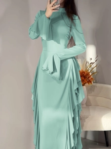 Détail de la robe longue vert clair à manches longues avec col montant et volants