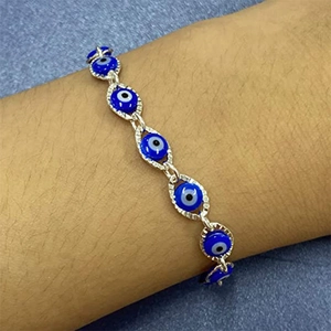 Ethnic blue evil eye bead bracelet with textured silver chain on female wrist