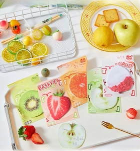 Macro shot of fruit-shaped sticky notes with vibrant realistic strawberry and apple prints