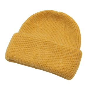 Detailed view of ginger yellow knitted beanie with classic ribbed weave and folded brim