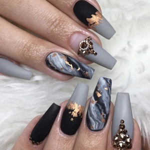 Detail of matte black and grey coffin nails with gold foil and marble patterns