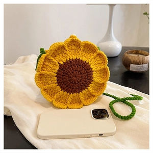 Detail of sunflower crochet crossbody bag showing texture and size with a phone